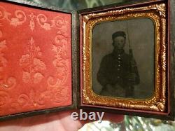 Very dark civil war tintype of young soldier with very unusual weapon armed case