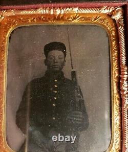 Very dark civil war tintype of young soldier with very unusual weapon armed case